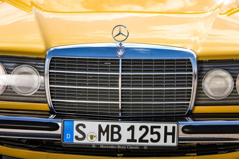 Mercedes-Benz 230 konštrukčného radu 123. Detailný pohľad spredu na ikonickú masku chladiča Mercedes.Mercedes-Benz 230 konštrukčného radu 123. Detailný pohľad spredu na ikonickú masku chladiča Mercedes.
